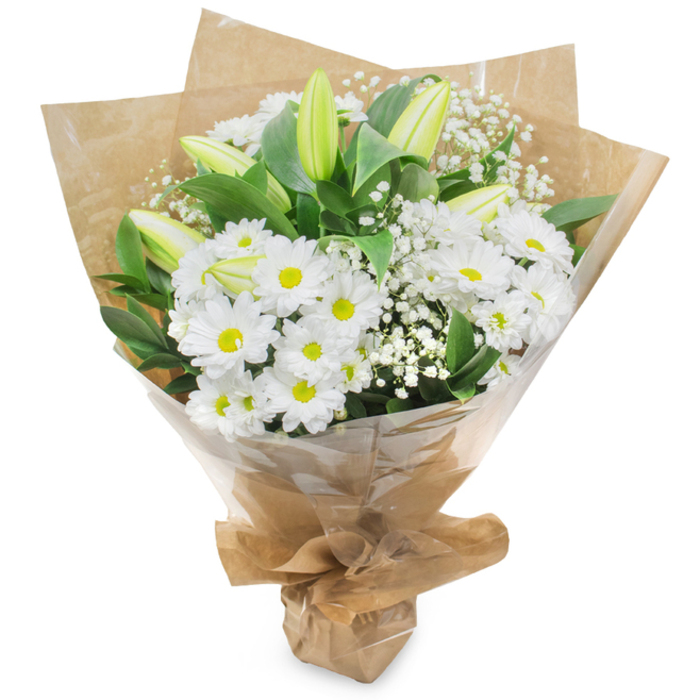 A tasteful, hand-tied bouquet rendered in a calming white-and-green palette, displayed upright on a neutral white background so each texture and tone is easily read. At its heart sits a generous cluster of white chrysanthemum blossoms - daisy-like, with layered petals fanning outward from small, sunny yellow centres that confer a classic, approachable cheer. Standing among them are several long, pale green-yellow lily buds; some show fine, subtle striping on their outer petals, a quiet sign of character and future unfolding blooms. Wisps of baby's breath (Gypsophila) are interlaced through the composition, their tiny white blooms producing a soft, clouded filler that breathes lightness into the arrangement. Dark green leaves and stems frame the flowers, offering contrast and a sense of depth so the whites read as luminous and pure. The bouquet is wrapped with artisan care: an inner layer of crinkled kraft paper lends an organic, tactile quality, while a protective outer sheet of clear cellophane allows the flowers themselves to remain the focus; the base is neatly gathered and secured, giving the bunch a tidy, portable stance. Bathed in soft diffused light - the kind that spills through the windows near Upper Street and Canonbury's cafés - the bouquet radiates simple elegance. Its scent is unobtrusive, a fresh green note with a hint of grassy clarity and the delicate perfume of lilies yet to open. Suited to quiet celebrations, housewarmings, thank-you gestures, or moments of remembrance, this arrangement communicates sincere care with the restrained beauty of classic floristry.