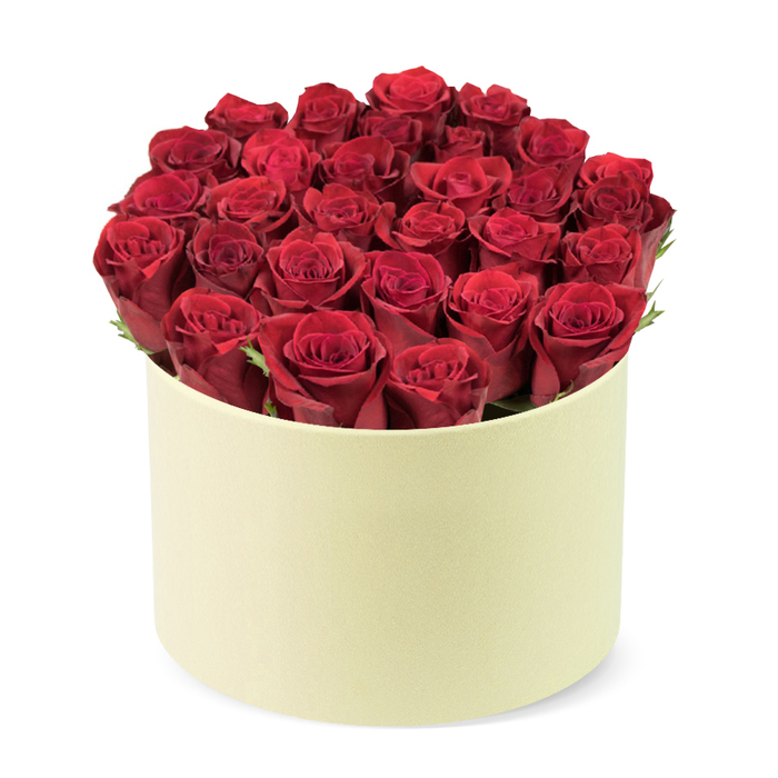 An opulent circle of crimson roses fills a round cream-colored box with a soft matte finish, creating a dense dome that rises just above the rim. Two dozen or so velvety blooms, with petals tightly furled and a luxurious depth of color, sit amid slim green foliage that threads through the heads, adding a natural highlight to the velvet red.

Seen against a pristine white background and photographed from a slightly elevated three-quarter angle, the arrangement communicates sophistication and exclusivity. It's the kind of gift that suits anniversaries, Valentine's Day, or a milestone celebration-a refined statement carried by a premium packaging design reminiscent of a hat box. In Canonbury's close-knit community, such a bouquet pairs beautifully with same-day delivery to nearby Islington, Dalston, and surrounding streets, bringing a touch of luxury to everyday life.

Craftsmanship matters here: each bloom is positioned by hand, careful to preserve balance and a sense of intimate abundance. The subtle greenery and the creamy neutral container enhance the intensity of the red, while the absence of visible stems or leaves on the top emphasizes lush fullness. This arrangement is a timeless, romantic gesture-ideal for Valentine's, anniversaries, or a poetically elegant gift, available for delivery across Canonbury and adjacent neighborhoods.