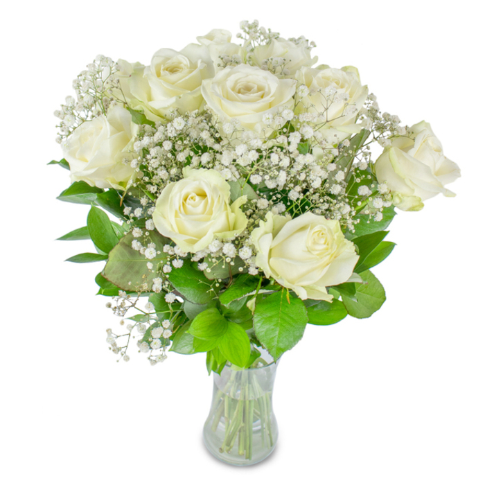 This composition of white roses and gypsophila is rendered with a calm, refined precision: roughly a dozen roses form the heart of the bouquet, some petals opened fully into satin cups while others retain a sweet, inward curl, suggesting movement and time held in a single arrangement. Tiny white clusters of baby's breath float between the main blooms, their minute, star-like blossoms lending a lacy, ethereal texture that makes the whole bouquet seem to breathe. Darker foliage provides a grounding contrast-leaves in deep emerald tones alongside paler, almost chartreuse greens-each leaf's glossy surface catching the light and framing the pale flowers like a living backdrop. The clear glass vase is simple and honest, exposing neatly trimmed stems and a visible water level that reinforces the sense of freshness and meticulous floristry. Shot against a luminous white background, the bouquet's whites read as pure and luminous, the composition echoing the understated celebrations that happen quietly around Canonbury Tower and local cafés on Essex Road. From a florist's perspective, arranging these stems feels like guiding a conversation: balance the fullness of the roses with the diaphanous touch of gypsophila, tuck leaves to shape the silhouette, and finish with clean stems that speak of care. The fragrance is barely there-clean and green-inviting intimacy rather than proclamation. Suitable for weddings, thoughtful anniversaries, or gentle remembrance, this bouquet gives off an air of timeless grace and composed affection.
