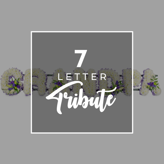 This refined funeral tribute image is composed with a graphic designer's eye and a florist's heart, set against a smooth, mid-tone grey background that lets the details take centre stage. Dominating the centre is a deep grey square panel bordered by a thin line of white, reminiscent of a tasteful service card or memorial announcement. Inside this frame, bold white typography reads 7 LETTER Tribute: the number 7 large and commanding at the top, LETTER smaller and neatly spaced below, and Tribute sweeping across the lower half in an elegant script that hints at something personal and custom-made. Emerging from either side of this central square are glimpses of a floral word tribute spelling GRANDMA. Each letter is three-dimensional and carefully shaped, its surface completely covered with pristine white chrysanthemums, or closely similar blooms, laid so densely that no gaps show through. Their many layered petals create a soft, velvety texture, giving the impression of purity and quiet love. Along the bases and edges of the letters, accents of rich purple flowers-perhaps lisianthus or small roses-are tucked in among glossy green foliage. These touches of colour form gentle clusters that draw the eye, adding depth and a sense of natural movement to the design. Only the curve of the G and fragments of the following R, A, N, D, M and final A are visible, as though the arrangement continues beyond the frame. The overall mood is one of respectful remembrance, the sort of personalised seven-letter tribute that Canonbury Flowers might prepare for families across Canonbury, Highbury, and nearby Barnsbury when they wish to celebrate a grandmother's life with grace and tenderness.