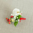 Resting on a pale beige woven fabric, this boutonniere centres on a pristine white phalaenopsis orchid whose creamy petals open in smooth, symmetrical curves to reveal a gentle yellow-orange throat. Surrounding it, fine sprays of gypsophila provide a frothy, ethereal texture-tiny white blossoms like a soft snowfall around the focal bloom. Bright clusters of red hypericum berries punctuate the design, their polished skins catching light and adding a joyful, almost festive counterpoint to the serene orchid. Slim, pale-green buds suggest freshness and growth, while broad, glossy green leaves, likely salal, cradle the cluster and introduce a grounding, verdant frame. The stems are neatly bound with a deep red satin ribbon knotted with care, the short tail extending to the right, lending a polished, personal finish.
A favourite at Canonbury Flowers, this style is often chosen for intimate weddings at Canonbury Square or for ceremonies near St. Paul's Road and the New River Walk. As a local florist I note how the neutral linen backdrop highlights the natural textures and the subtle play of light on each element. The boutonniere feels sophisticated yet approachable-perfect for a groom or guest wanting a touch of refined colour that reflects Canonbury's leafy charm and understated elegance.