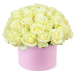 A generous cluster of creamy white roses, impossibly full and velvety, rises from a round pastel pink hat box like a carefully sculpted dome of petals. Each rose is positioned closely against its neighbour, creating a continuous surface of soft, spiralling blooms that transition from near-white on the outer petals to hints of pale ivory and buttery cream near the centres. The flowers appear freshly opened, with petals gently curling back in relaxed, natural folds, suggesting they were arranged only recently in a Canonbury florist's studio. Here and there, small touches of bright green foliage sneak through at the base of the dome, giving the eye a welcome contrast and a reminder of the stems hidden beneath. The hat box itself is a delicate blush pink with a smooth, matte texture, more akin to luxury gift packaging than a traditional vase, and its cylindrical form supports the roses like a low pedestal. The colour of the box subtly echoes the romance of an anniversary evening along nearby Upper Street, while allowing the soft neutrals of the roses to remain the star. The entire arrangement is photographed against a pure white backdrop, free of clutter, so that every curve of each petal and the harmonious layering of tones are easy to imagine through description alone. This design feels calm and intimate, perfect for marking significant anniversaries, proposals, or quiet celebrations at home in Canonbury. It captures modern floral style-the convergence of minimal lines, refined textures, and classic blooms-while radiating warmth, devotion, and understated luxury.