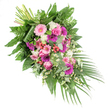 This image shows a beautifully composed funeral spray that stretches in a gentle diagonal, as though drifting from the upper left corner of the frame to the lower right, laid out on a crisp white background. The colour story is both romantic and dignified, woven from soft pinks, intense fuchsias, deep purples, and clear whites, resting on a bed of rich green leaves. Prominent throughout are wide-faced gerbera daisies, some in pale blush, others in bold magenta, their layered petals radiating from dark centres like quiet suns. Nestled among them are elegant pink roses, their tightly wound spirals suggesting both fragility and strength in the face of loss. Clusters of fluffy white blooms-carnations or diminutive chrysanthemums-introduce a cushiony, cloud-like texture that softens the bolder tones. Small, dainty white daisy-style flowers are scattered like stars, bringing an airy, meadow-like charm that feels at home in the calm corners of Canonbury's residential gardens. Bright red hypericum berries gleam between petals, adding tiny, rounded accents of colour and a hint of woodland character. The foliage is layered and abundant: broad, glossy greens offer a sturdy base; finely cut ferns create a feathery edge; and soft eucalyptus leaves lend a silvery undertone and a subtle suggestion of fragrance. From the lower right, long palm fronds sweep outward, enhancing the sense of flow, while at the upper left, a neat bundle of green stems reveals the hand-tied craftsmanship. The lighting is soft and even, allowing every petal and leaf to be clearly seen. Suitable as a casket spray or significant tribute for funerals and memorials around Canonbury, this arrangement conveys peace, remembrance, and gentle comfort.